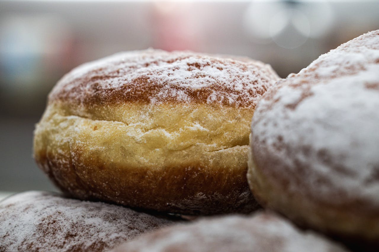 home-services-02 Close-up of freshly baked Berliner donuts with powdered sugar. Ideal for food and culinary content.