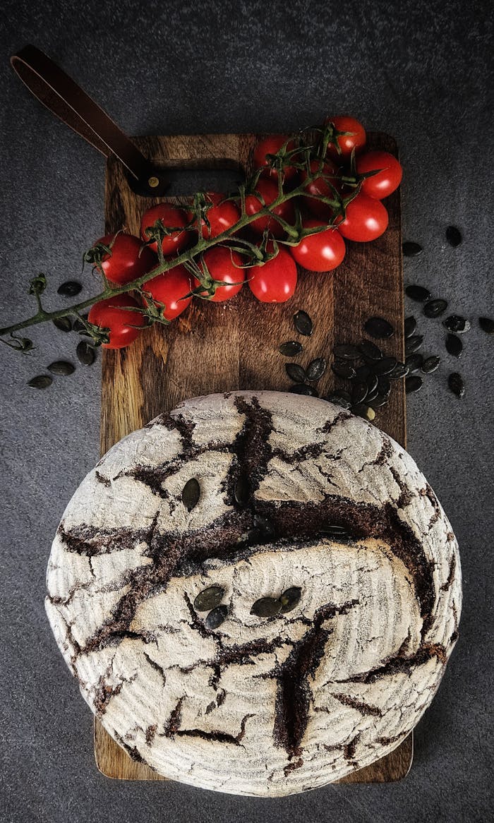 about-01 Freshly baked rustic bread on a wooden board with vine ripened tomatoes.